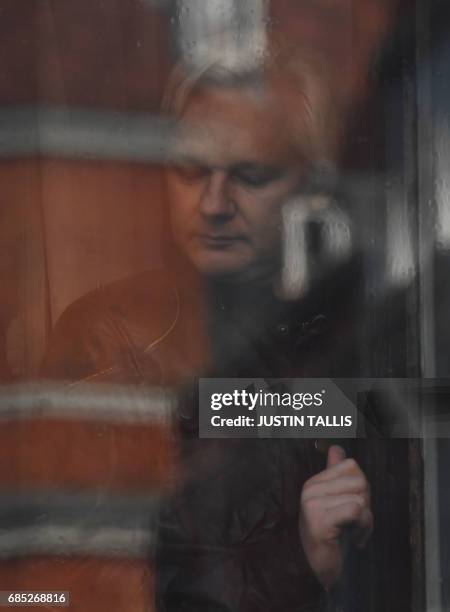 Wikileaks founder Julian Assange appears at the window of the balcony prior to making an address to the media at the Embassy of Ecuador in London on...