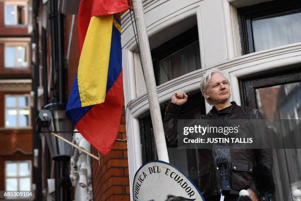 Wikileaks founder Julian Assange raises his fist prior to addressing the media on the balcony of the Embassy of Ecuador in London on May 19, 2017. -...