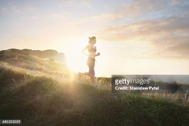 young woman running near ocean - jogging photos et images de collection