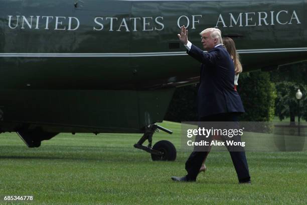 President Donald Trump and first lady Melania Trump walk on the South Lawn prior to their departure on the Marine One from the White House May 19,...