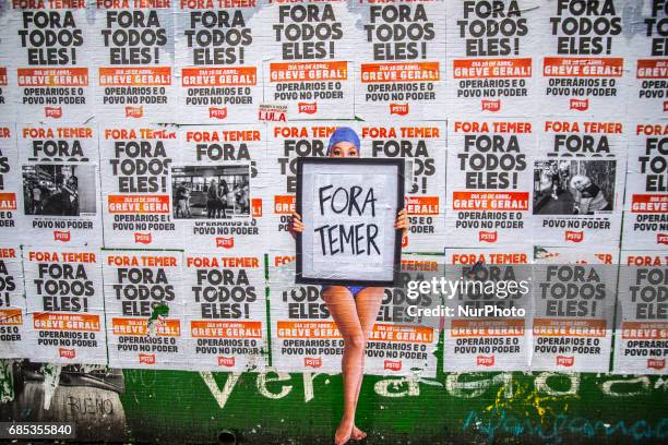 Wheat-paste piece of street art by artist Luis Bueno depicting a bather holding a poster that says &quot;Outside Temer&quot; at Paulista Avenue on...