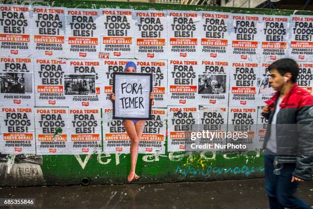 Wheat-paste piece of street art by artist Luis Bueno depicting a bather holding a poster that says &quot;Outside Temer&quot; at Paulista Avenue on...