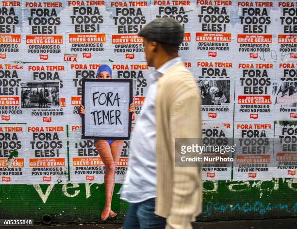 Wheat-paste piece of street art by artist Luis Bueno depicting a bather holding a poster that says &quot;Outside Temer&quot; at Paulista Avenue on...