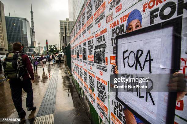 Wheat-paste piece of street art by artist Luis Bueno depicting a bather holding a poster that says &quot;Outside Temer&quot; at Paulista Avenue on...