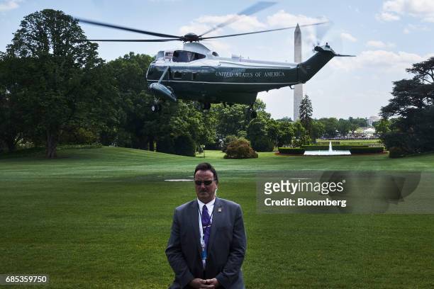 Member of the U.S. Secret Service stands as Marine One, with U.S. President Donald Trump on-board, departs the South Lawn of the White House in...