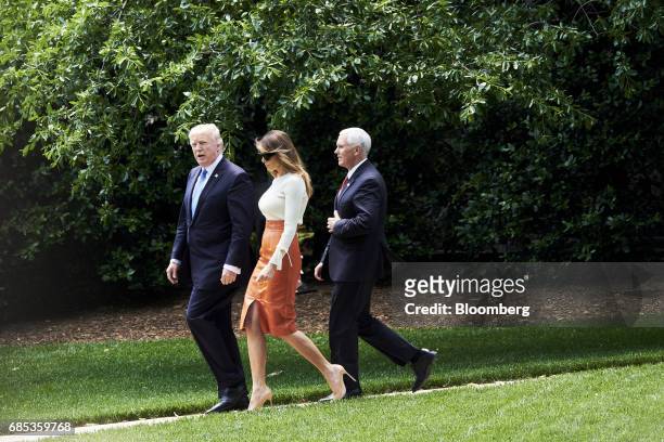 President Donald Trump, from left, First Lady Melania Trump, and Vice President Mike Pence walk towards Marine One on the South Lawn of the White...