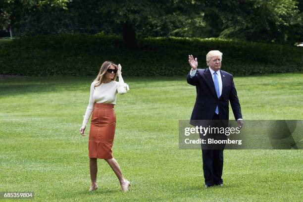 President Donald Trump waves as First Lady Melania Trump smiles while walking towards Marine One on the South Lawn of the White House in Washington,...