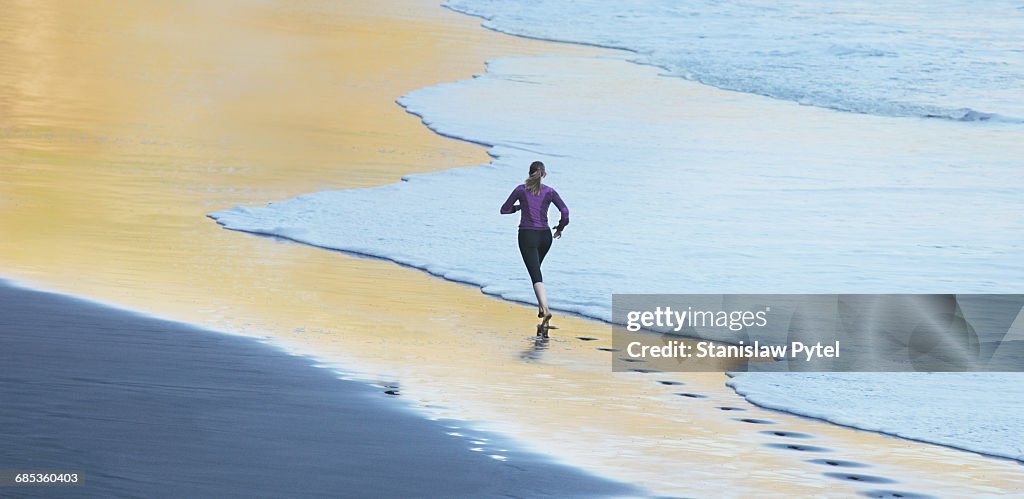 Woman running on gold beach