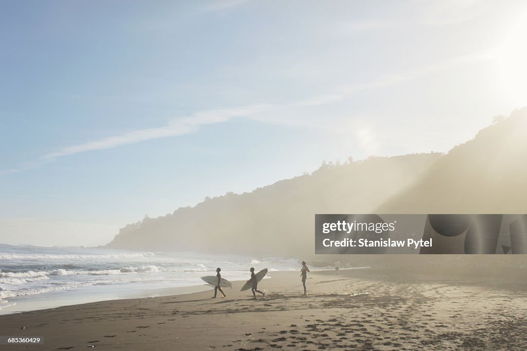 Silhouettes of kids preparing to surf