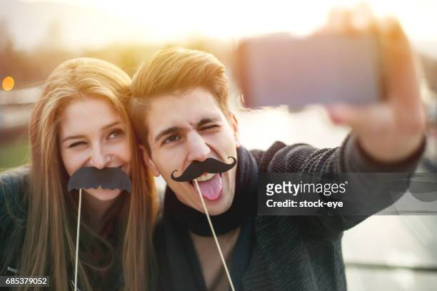 selfie mit gefälschten schnurrbärte - movember stock-fotos und bilder