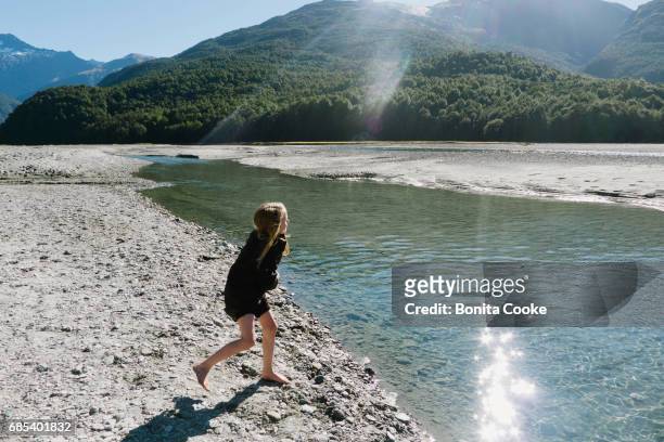 girl throwing stones into the river - kids at river stock pictures, royalty-free photos & images