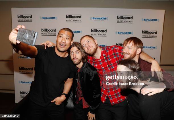 Michael Yo takes a selfie with Wayne Sermon, Dan Reynolds, Ben McKee, and Daniel Platzman of Imagine Dragons following a SiriusXM's "Hits 1 in...