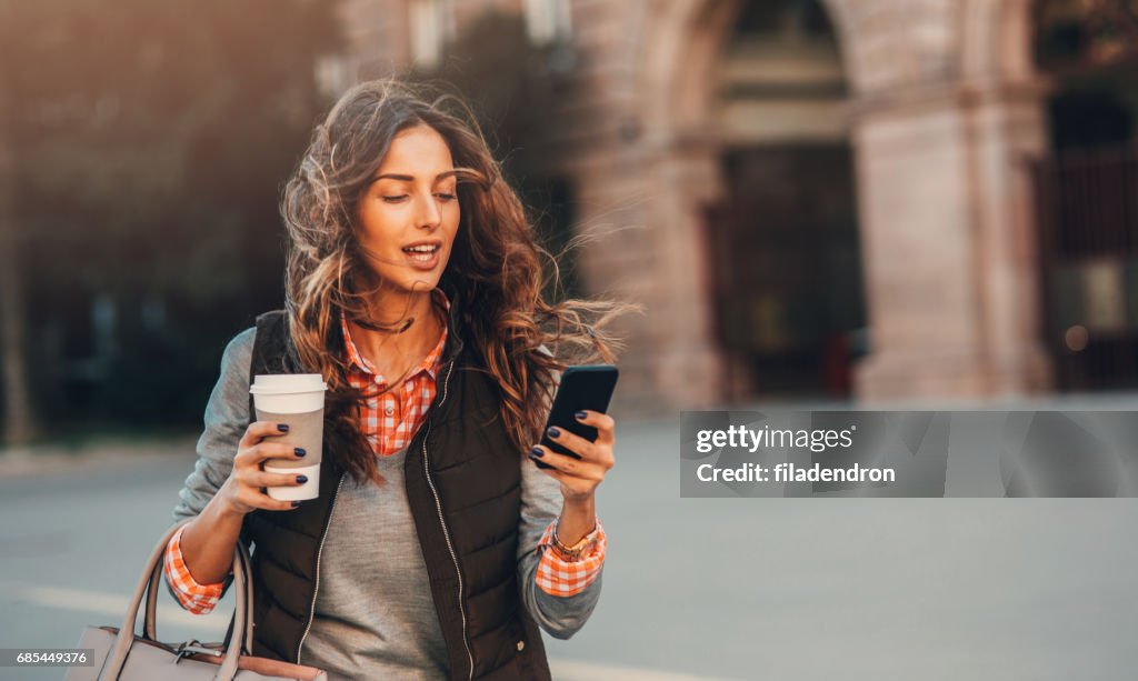 女人發短信，在戶外喝咖啡。