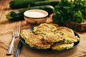 Vegetarian food - zucchini fritters on wooden background.