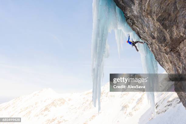 männliche alpinistisches eisklettern auf scharfen eiszapfen - eisklettern stock-fotos und bilder