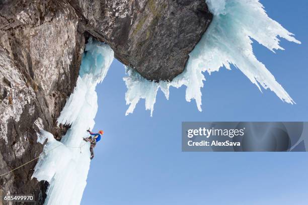 男アイス ピッケルを使用して冷凍岩壁のクライミング - ice pick ストックフォトと画像