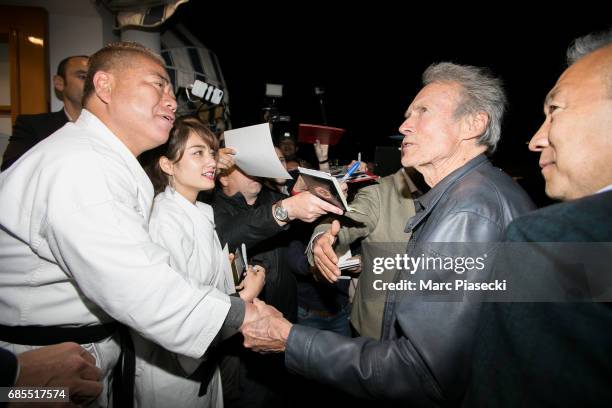 Tetsuro Degawa meets actor Clint Eastwood as he leaves the 'Tetou' restaurant during the 70th annual Cannes Film Festival on May 19, 2017 in Golfe...