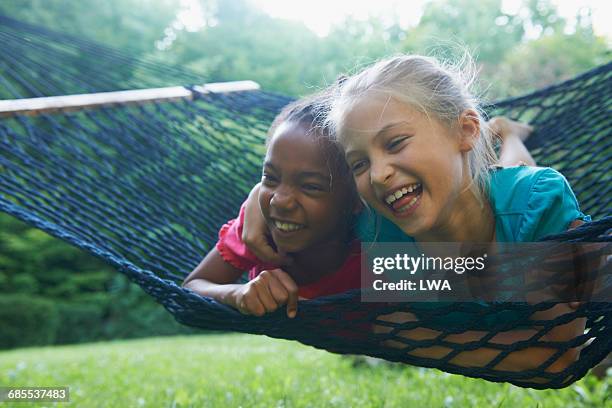 young girls in hammock - friendship kids stock-fotos und bilder