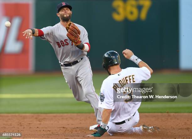 Dustin Pedroia of the Boston Red Sox completes the double-play by getting his throw off over the top of Trevor Plouffe of the Oakland Athletics in...