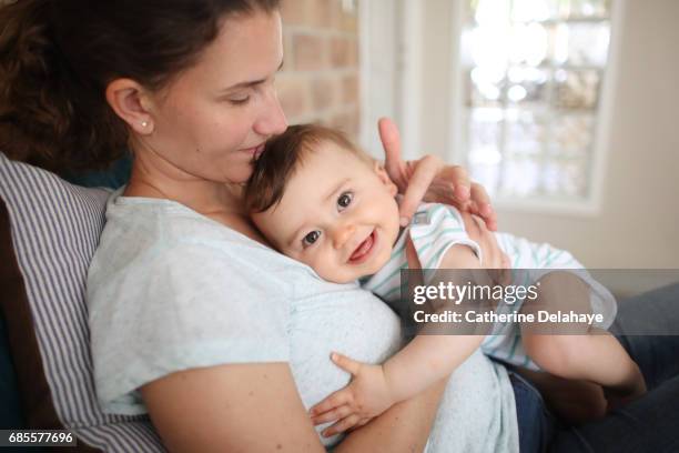 a 8 months old baby in the arms of his mum - mom looking at camera stock pictures, royalty-free photos & images