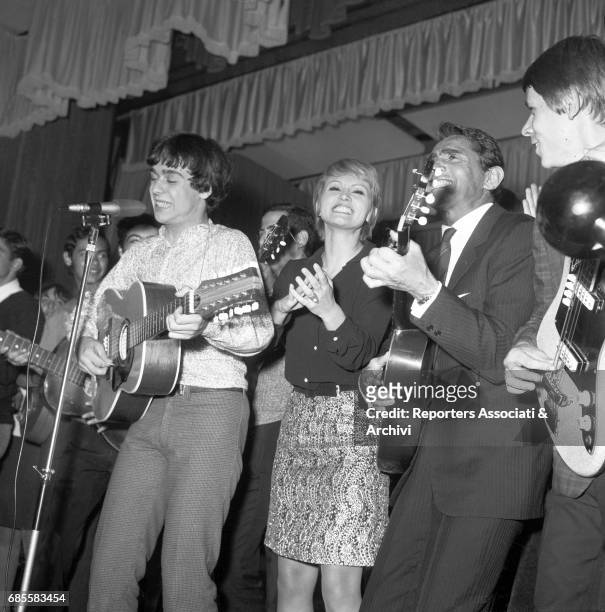 Italian actor, comedian and TV host Walter Chiari and Italian actress Carmen Villani singing and playing music with her band. Italy, 1962