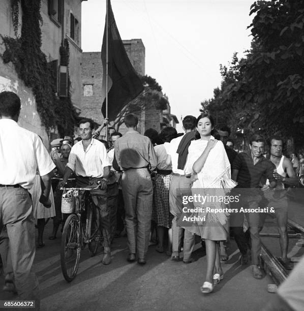 French actress Jacqueline Sassard walking in the street surrounded by the crowd in a scene from the film 'Violent Summer', directed by Valerio...