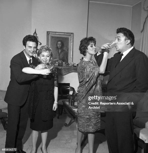 Italian actors Franco Interlenghi, Giulietta Masina and Antonella Lualdi and Italian director Federico Fellini having a toast for New Year's Eve at...