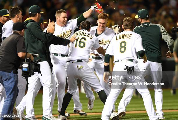Mark Canha of the Oakland Athletics and teammates celebrates Canha hitting a walk off solo home run to defeat the Boston Red Sox 3-2 in the bottom of...