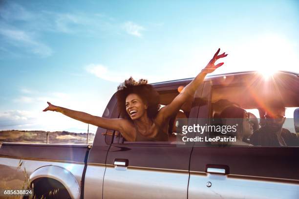 young friends enjoying the freedom on a car trip over a country offroad - carefree stock pictures, royalty-free photos & images