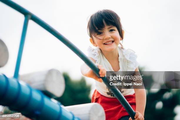 cute 3 year old mixed race girl having fun at playground - playground stock photos et images de collection