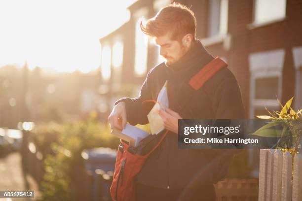 postman porting post on urban street - postal worker stock pictures, royalty-free photos & images