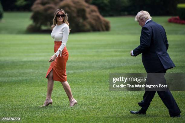 President Donald Trump and first lady Melania Trump walk across the South Lawn to board Marine One and fly to Andrews Air Force Base, Md., at the...