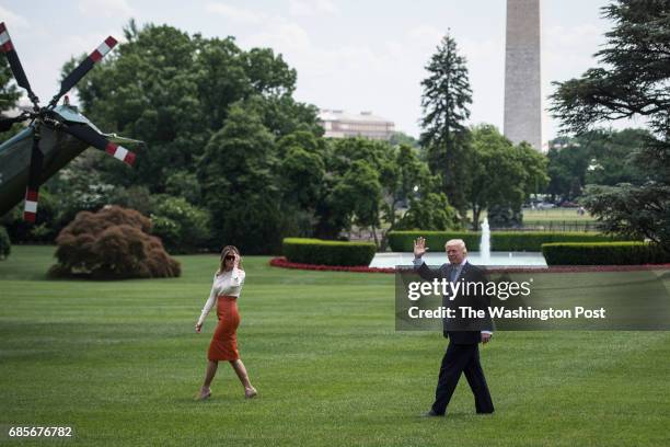 President Donald Trump and first lady Melania Trump stop to wave as they walk across the South Lawn to board Marine One and fly to Andrews Air Force...