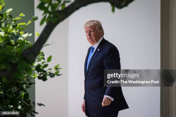 President Donald Trump walks out of the Oval Office to board Marine One for a short trip to Andrews Air Force Base, Md., at the White House in...