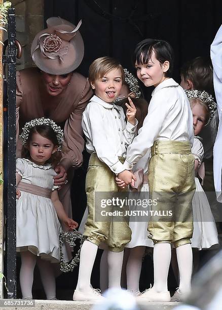 Britain's Catherine, Duchess of Cambridge stands with her daughter Britain's princess Charlotte, and the other bridesmaids and pageboys, as they...