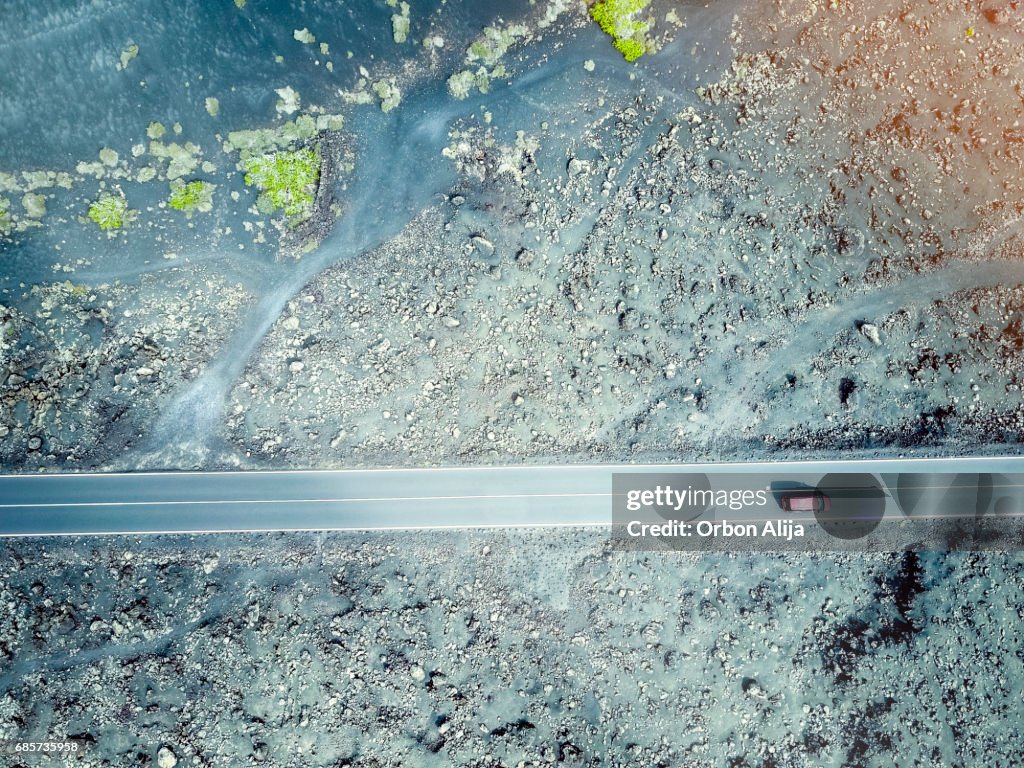 Aerial image of a car driving through a road in Lanzarote, Spain.