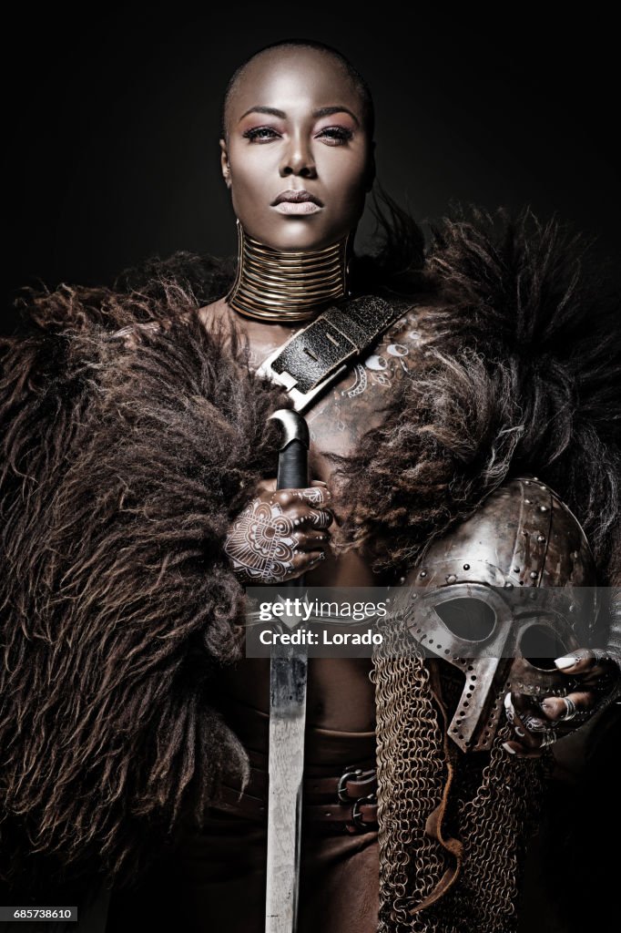Beautiful black warrior princess holding a sword in studio shot