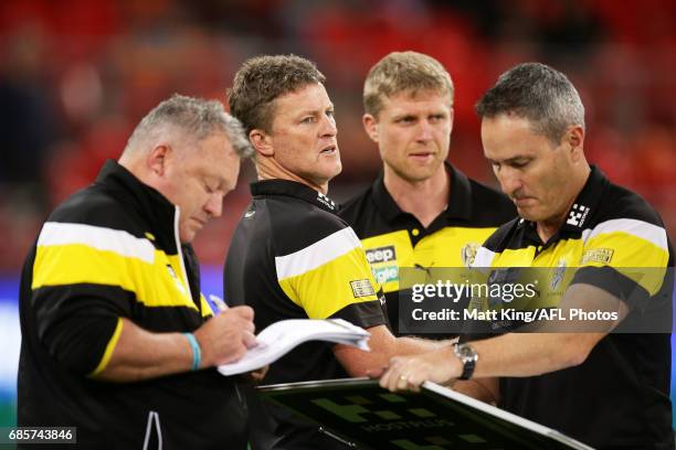 Tigers head coach Damien Hardwick speaks to coaches at three quarter time during the round nine AFL match between the Greater Western Sydney Giants...