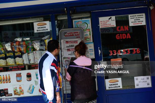 People look at the latest copy of opposition daily newspaper Sozcu bearing the headline reading " May 19 Freedom of Press special edition" on a blank...