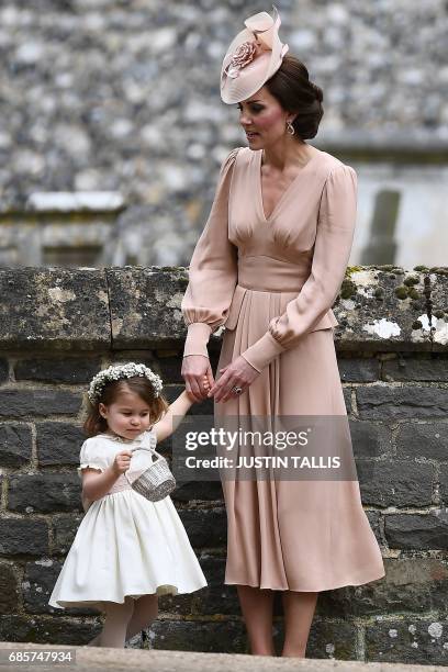 Britain's Catherine, Duchess of Cambridge stands with her daughter Britain's princess Charlotte, a bridesmaid, following the wedding of her sister...