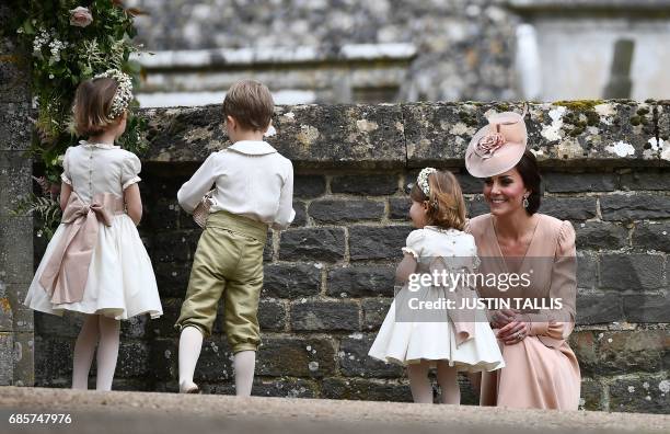 Britain's Catherine, Duchess of Cambridge stands with her daughter Britain's princess Charlotte, a bridesmaid, following the wedding of her sister...