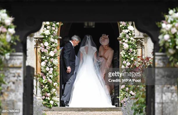 Britain's Catherine, Duchess of Cambridge , adjusts the dress of her sister Pippa Middleton as their father, Michael Middleton stands by at the door...