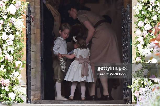 Britain's prince George , a pageboy, Britain's princess Charlotte, a bridesmaid, stand with their nanny Maria Borrallo, as they attend the wedding of...