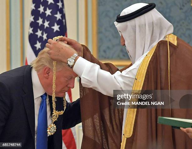 President Donald Trump receives the Order of Abdulaziz al-Saud medal from Saudi Arabia's King Salman bin Abdulaziz al-Saud at the Saudi Royal Court...