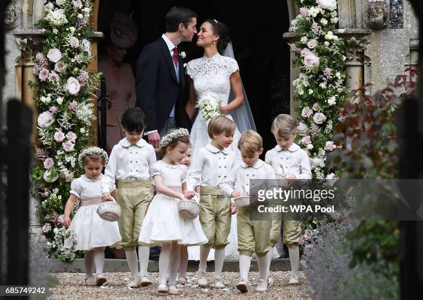 Pippa Middleton kisses her new husband James Matthews, following their wedding ceremony at St Mark's Church as the bridesmaids and pageboys walk...