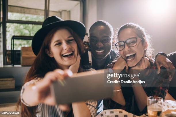 vrienden die een selfie maken - sun flare on glass stockfoto's en -beelden