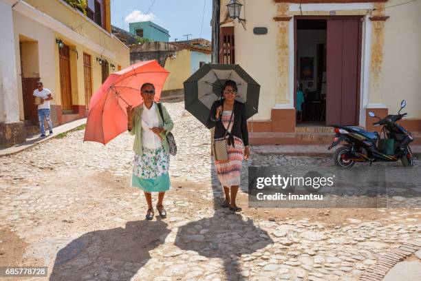 two woman with umbrellas - heritage month stock pictures, royalty-free photos & images