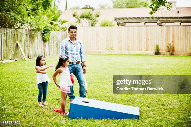man playing game with nieces in backyard during birthday party - niece fotografías e imágenes de stock