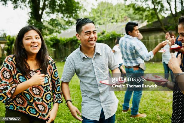 laughing family members sharing cake in backyard during birthday party - texas family stock pictures, royalty-free photos & images