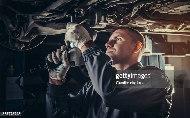 meccanico professionista che ripara un'auto in officina - auto repair shop foto e immagini stock